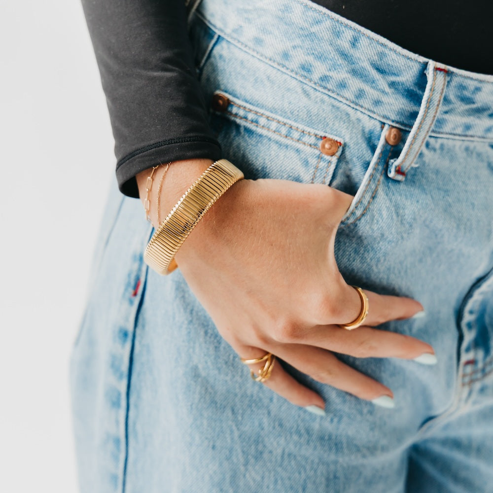 Chunky ribbed gold bangle bracelet on wrist