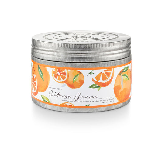 Round soy candle in round metal tin with orange citrus label and silver lid