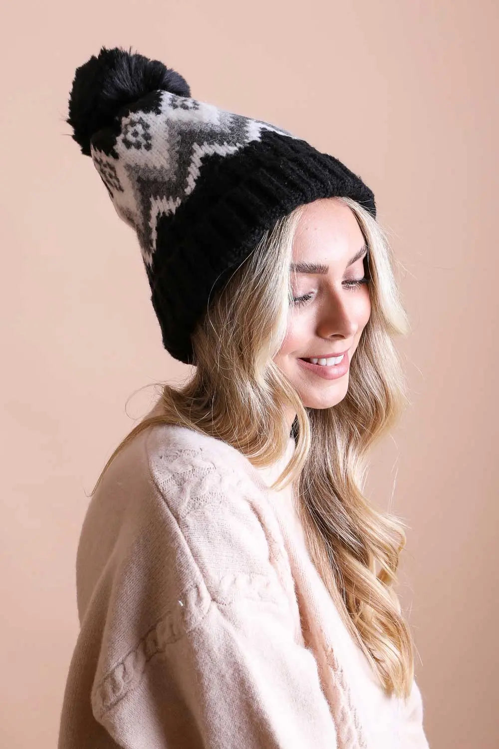 Black knit winter beanie with white zigzag fair isle pattern and black pom-pom