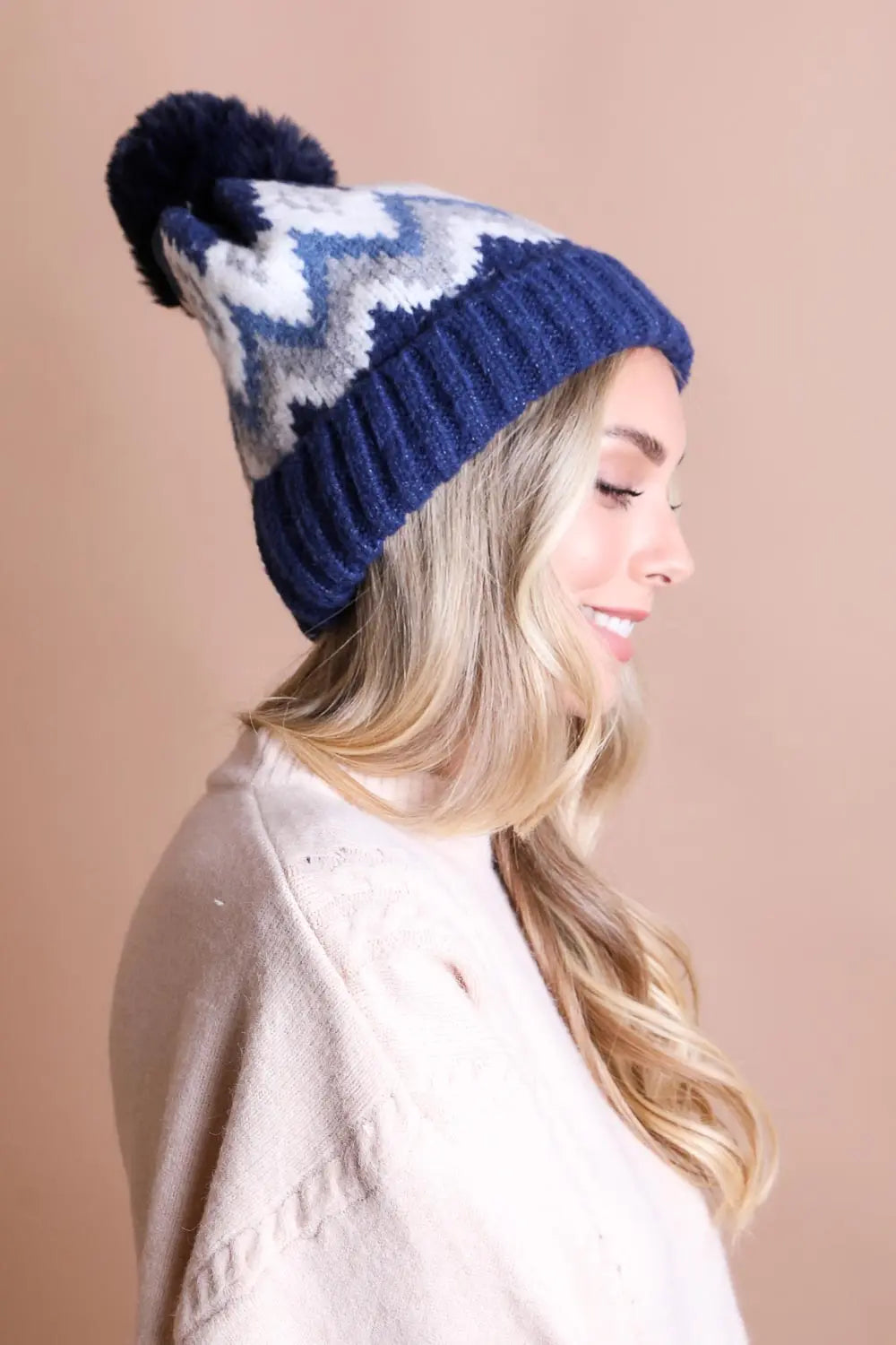 Navy knit winter beanie with white fair isle star pattern and dark pom-pom