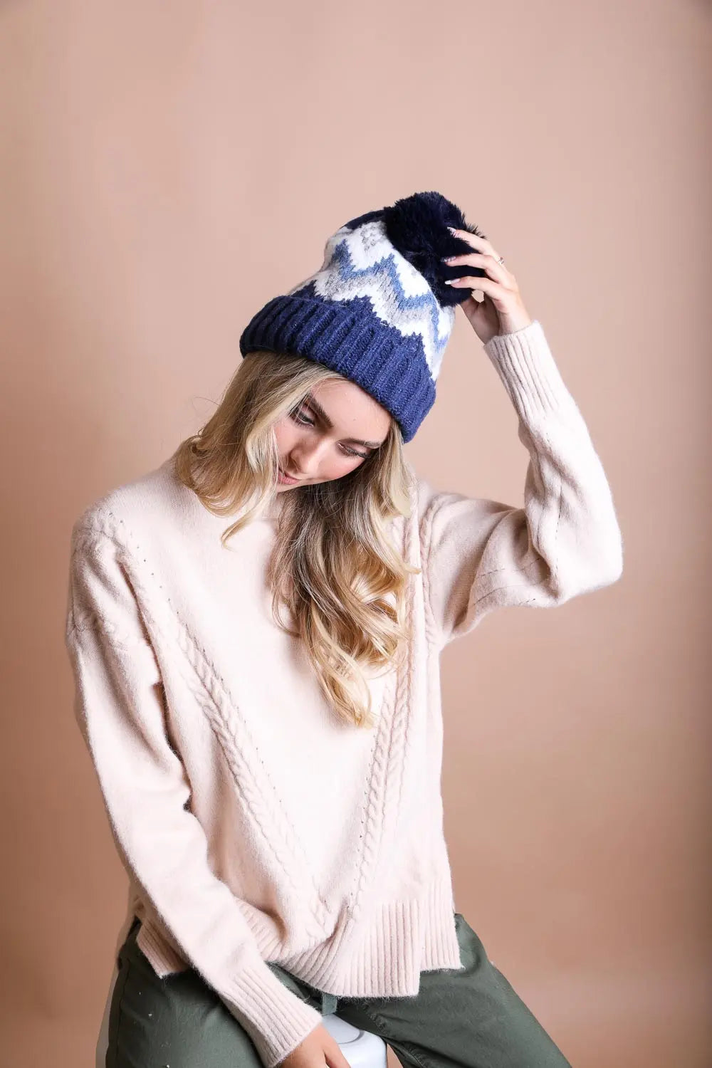 Navy and white fair isle knit beanie with pom-pom, worn with a cream sweater