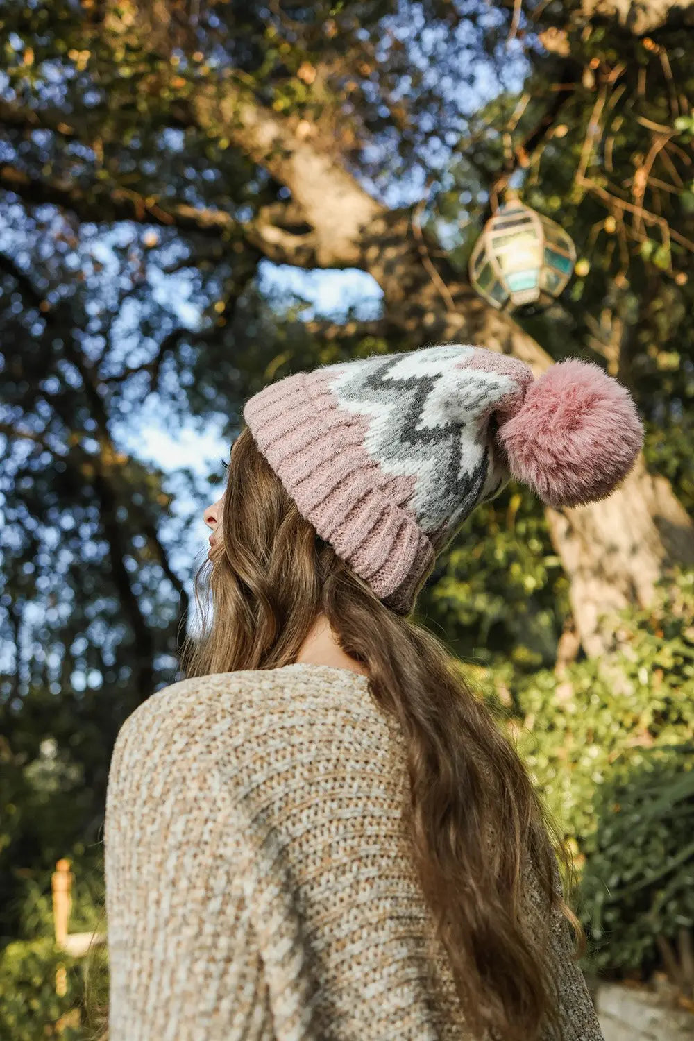 Beige fair isle knit beanie with light gray pattern and pink pom-pom