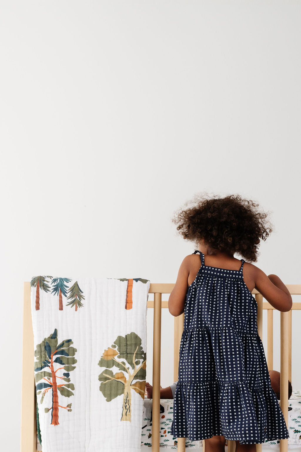 Forest trees quilt on crib, white cover with woodland tree illustrations