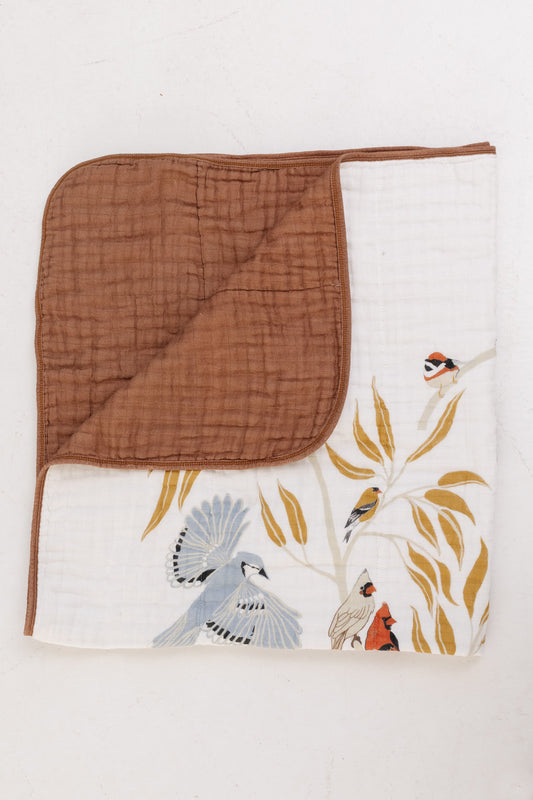 Folded baby quilt: white bird print front with brown solid back panel