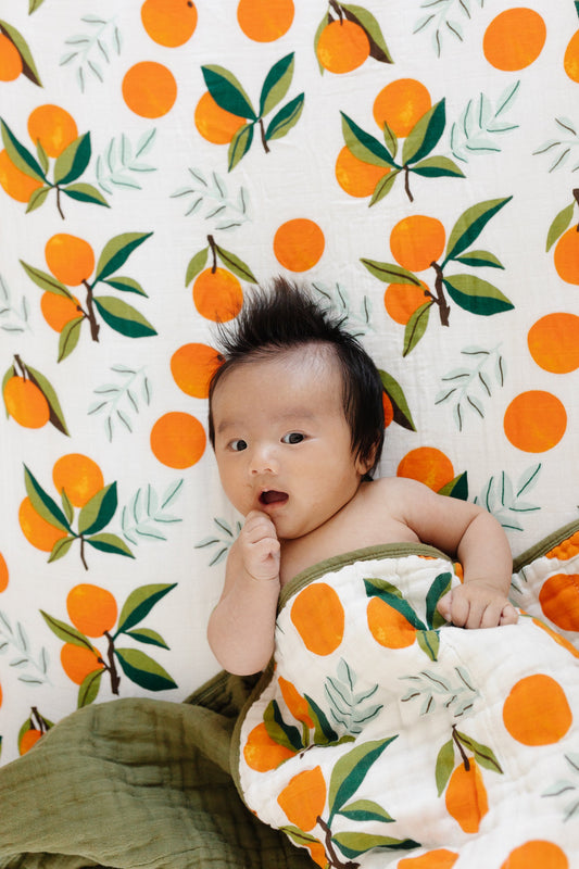 Fresh Clementine quilt with orange fruit and leaf print, white base, green edge border