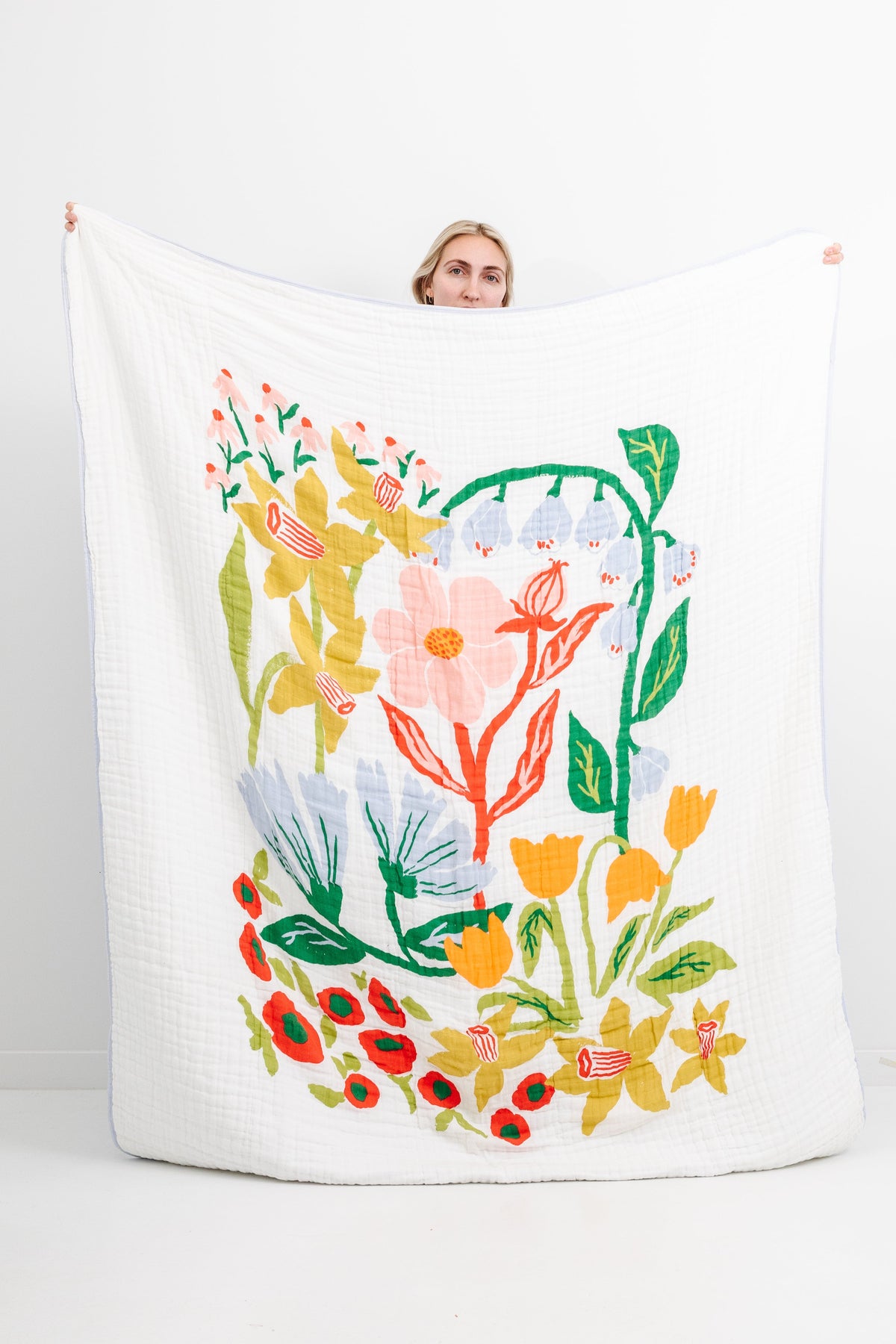 White quilted throw blanket with multicolor cottage garden floral print