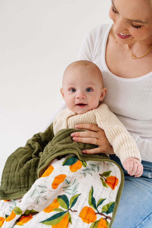 Clementine-themed baby quilt blanket with orange fruit pattern and green border
