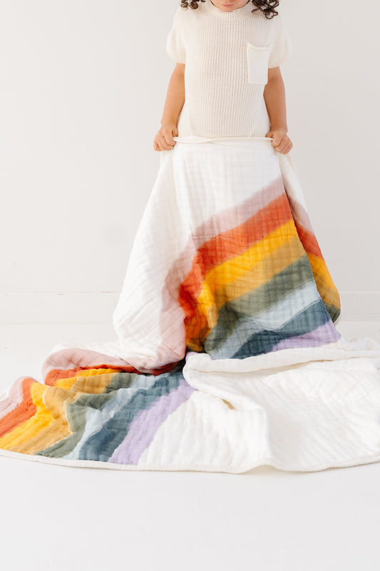 Rainbow quilt with colorful rainbow arc stripes on white cotton blanket