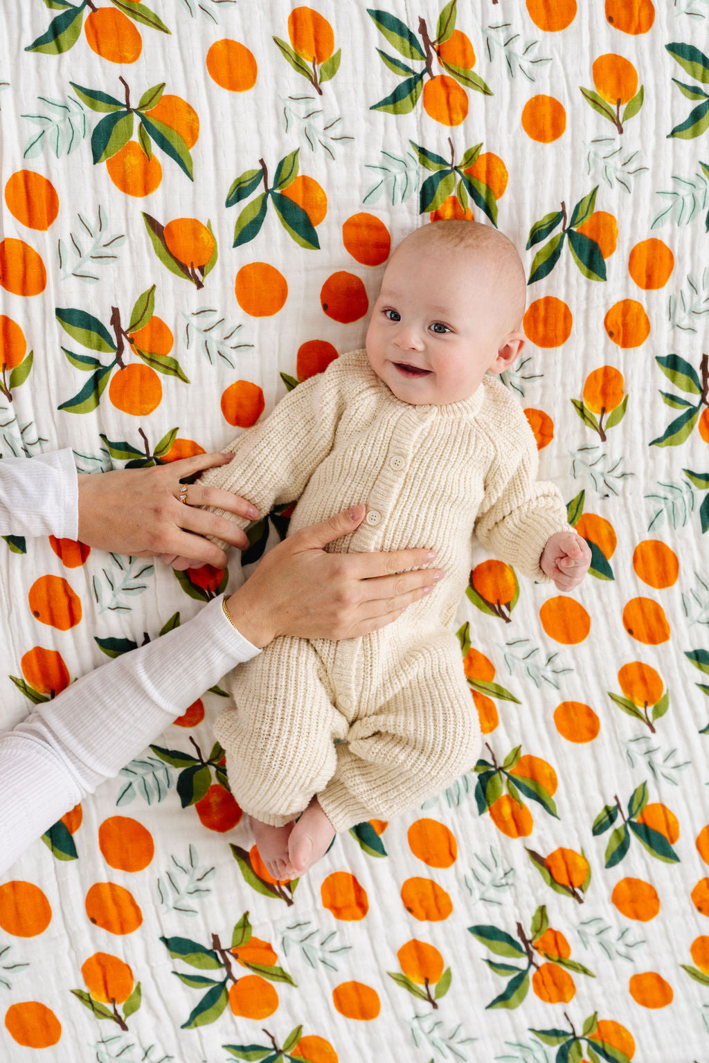Orange clementine and green leaf printed quilt blanket with green trim edge