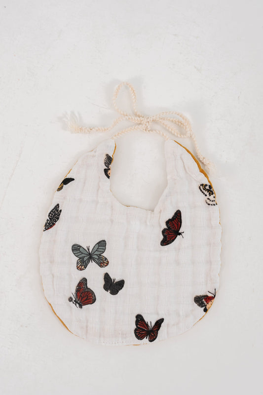White muslin baby bib with multicolor butterfly pattern and scalloped neck tie