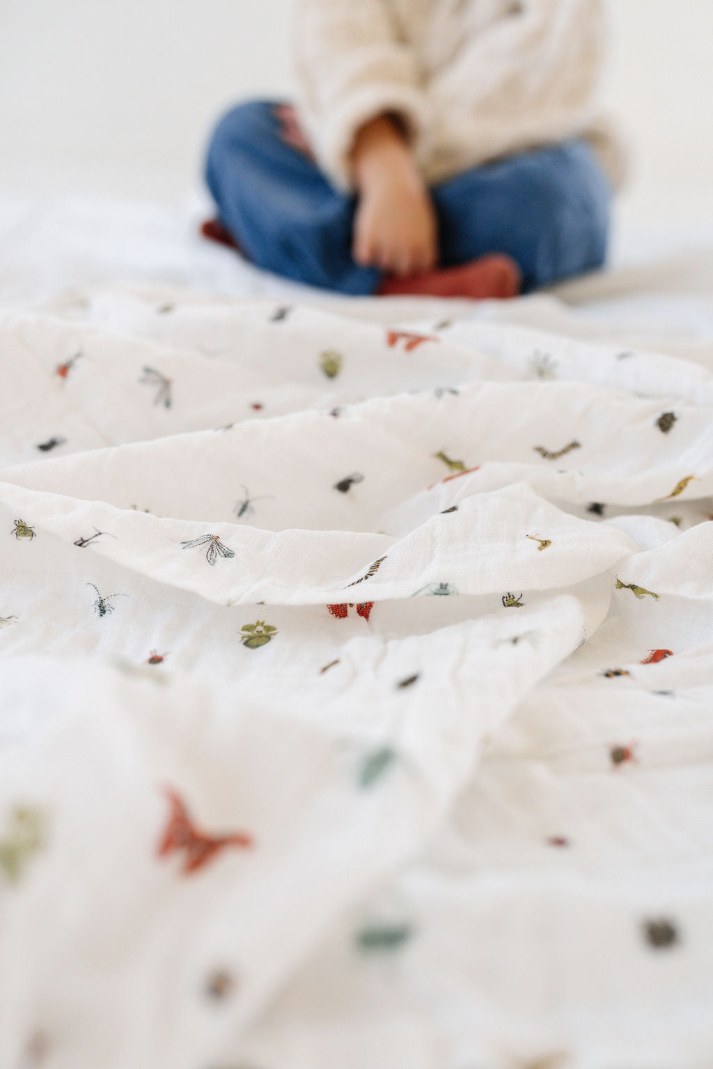 Close-up of white baby swaddle blanket with tiny animal print pattern