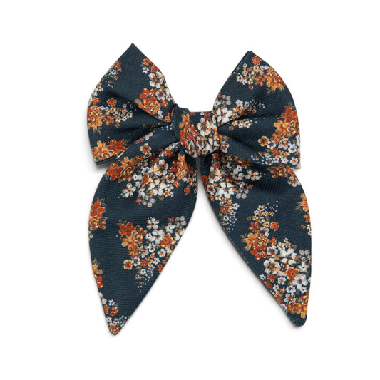 Floral hair bow with dark navy fabric and orange, white, and light blue flower print
