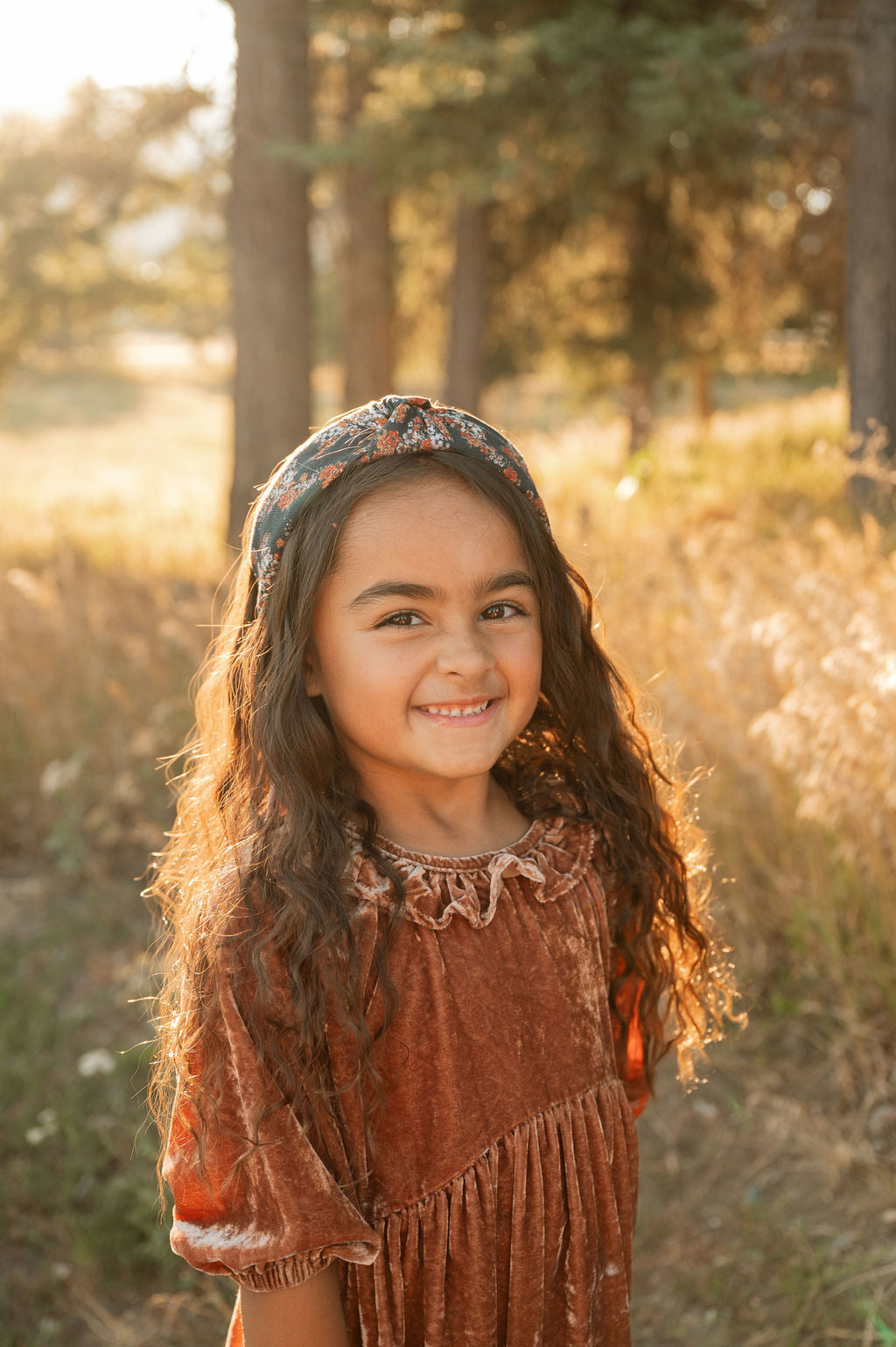 Knotted floral headband on child, dark navy with orange floral print