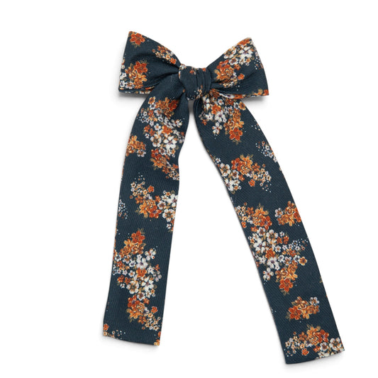 Navy floral lady hair bow with orange and white blossoms and long ribbon tails