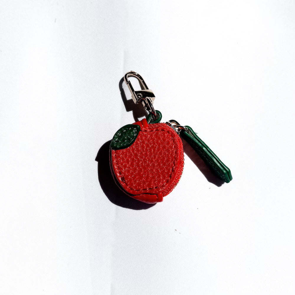 Red fruit leather keychain charm with green cap and green hanging tassel.