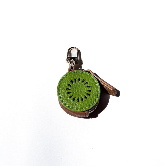 Kiwi-shaped leather keychain charm with green center, brown sides, and black seeds.