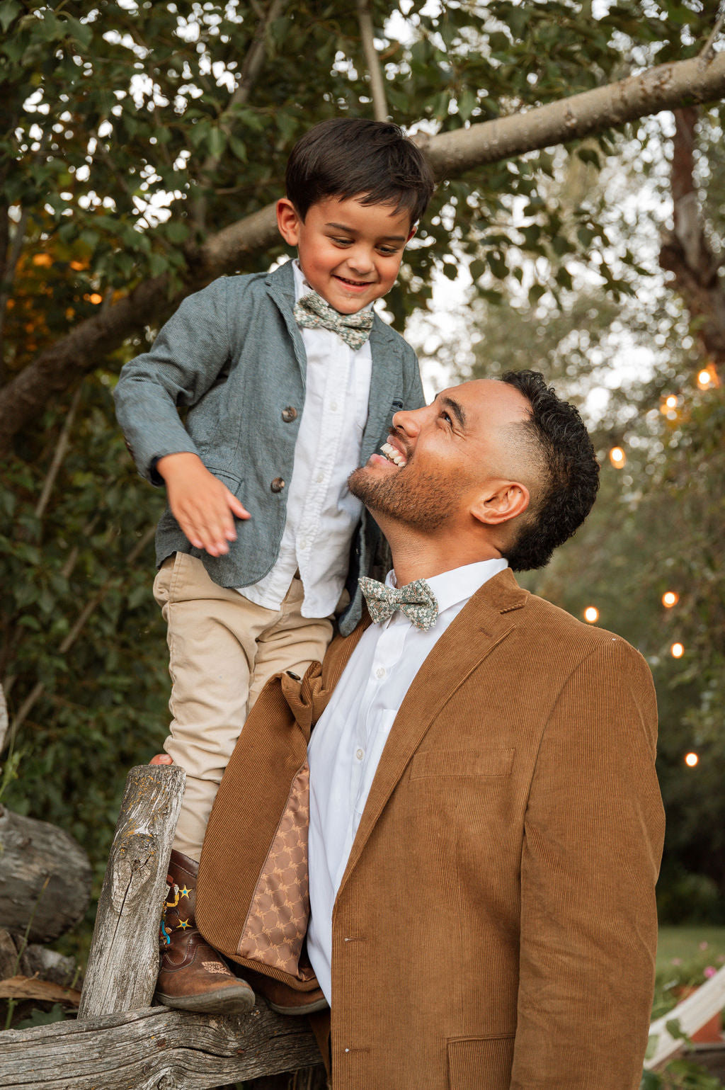 Boys green floral bow tie with white and tan flowers, worn at neckline