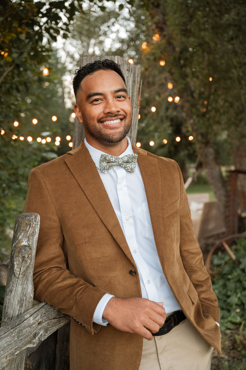 Men's pre-tied bow tie with green floral pattern and cream bloom details