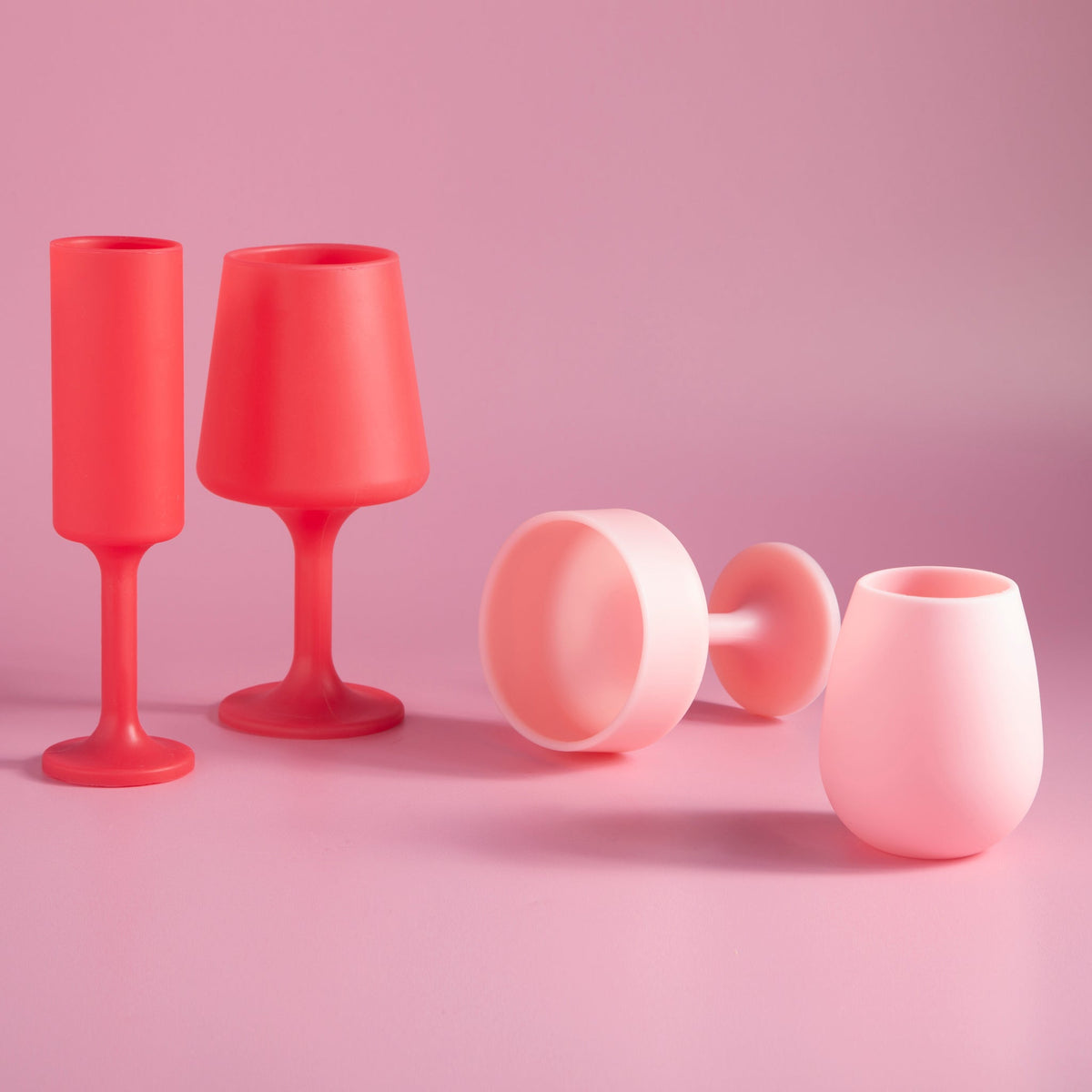 Multiple silicone tulip glasses in cherry red and blush pink, some lying sideways