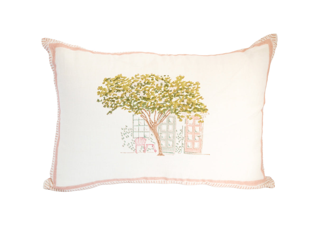 Block print cushion with tree-and-house motif and pink stitched edge trim