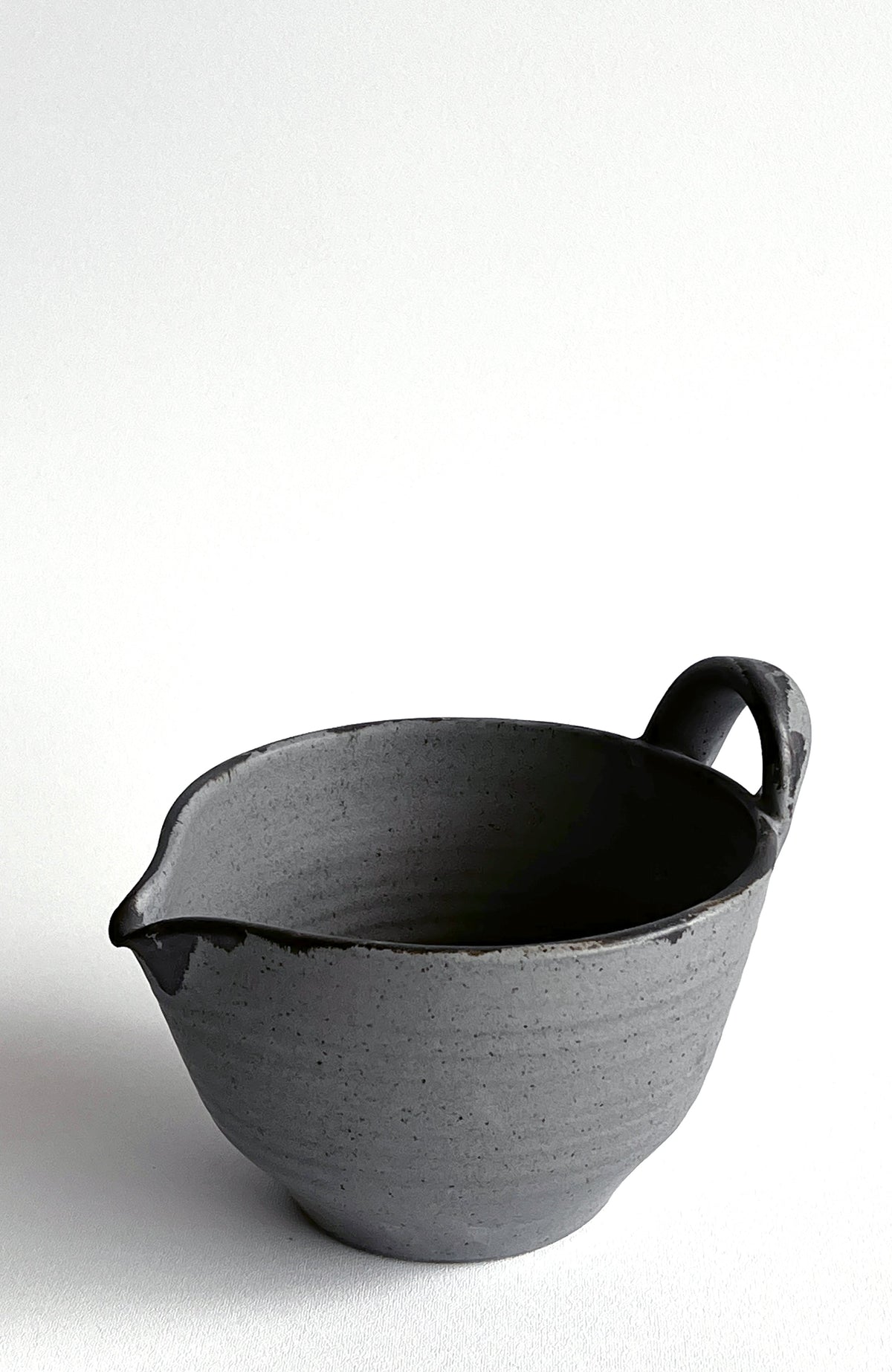 Dark gray batter bowl with speckled glaze and side loop handle