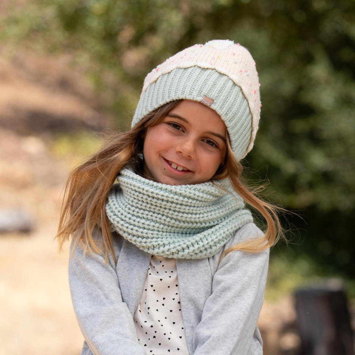 Cream sprinkle-knit beanie with mint green cuff, modeled with a matching knit scarf