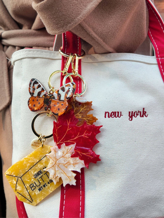 Butter bag keychain charm close-up with leaf dangles and gold rings