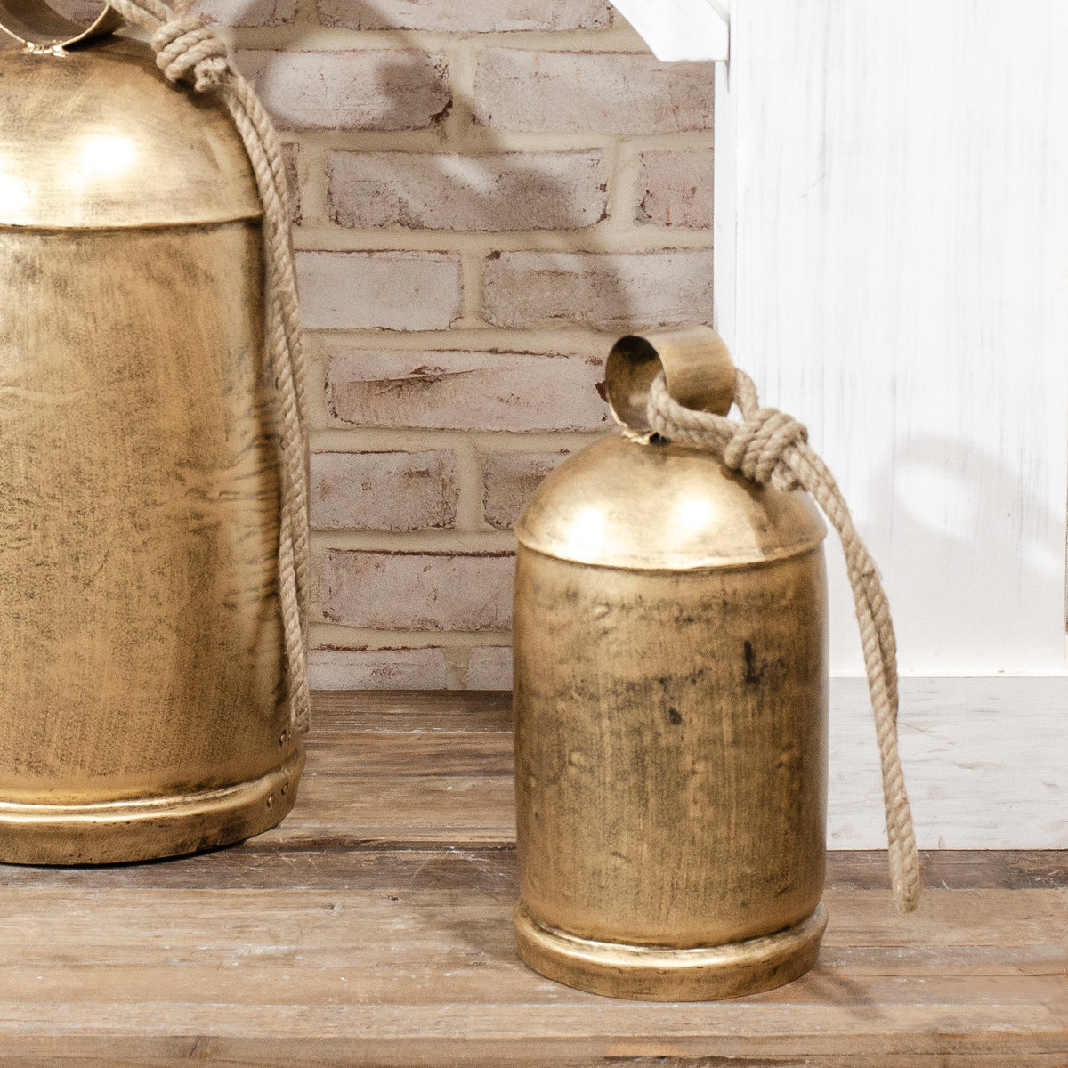 Gold distressed metal bell with braided rope handle, rounded top loop