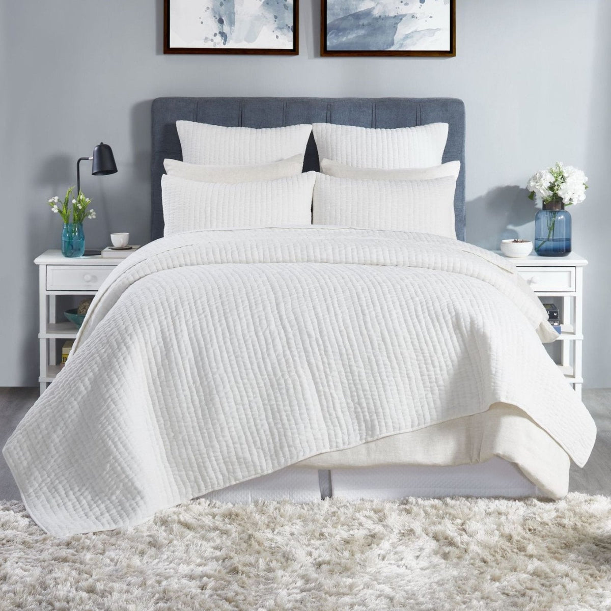 White washed-cotton quilt on a bed with matching textured pillow shams