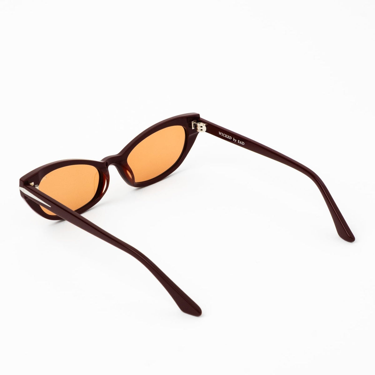 Burgundy cat-eye sunglasses with amber tinted lenses and curved dark temple tips