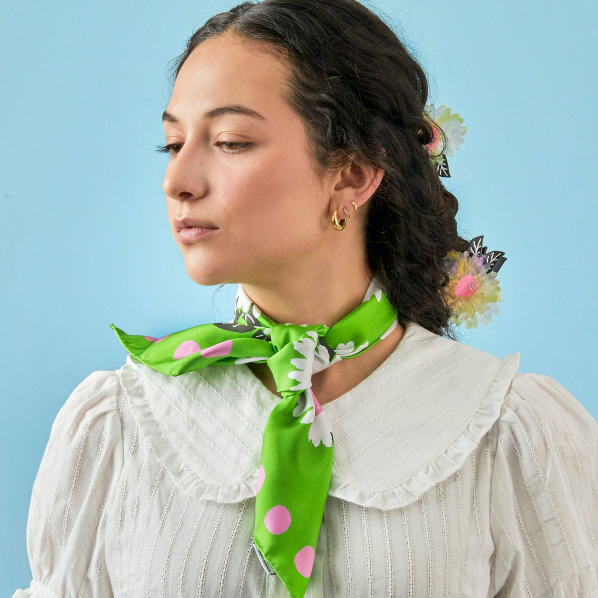 Green silk neck scarf with white and pink flowers, pink dots, and a tied knot