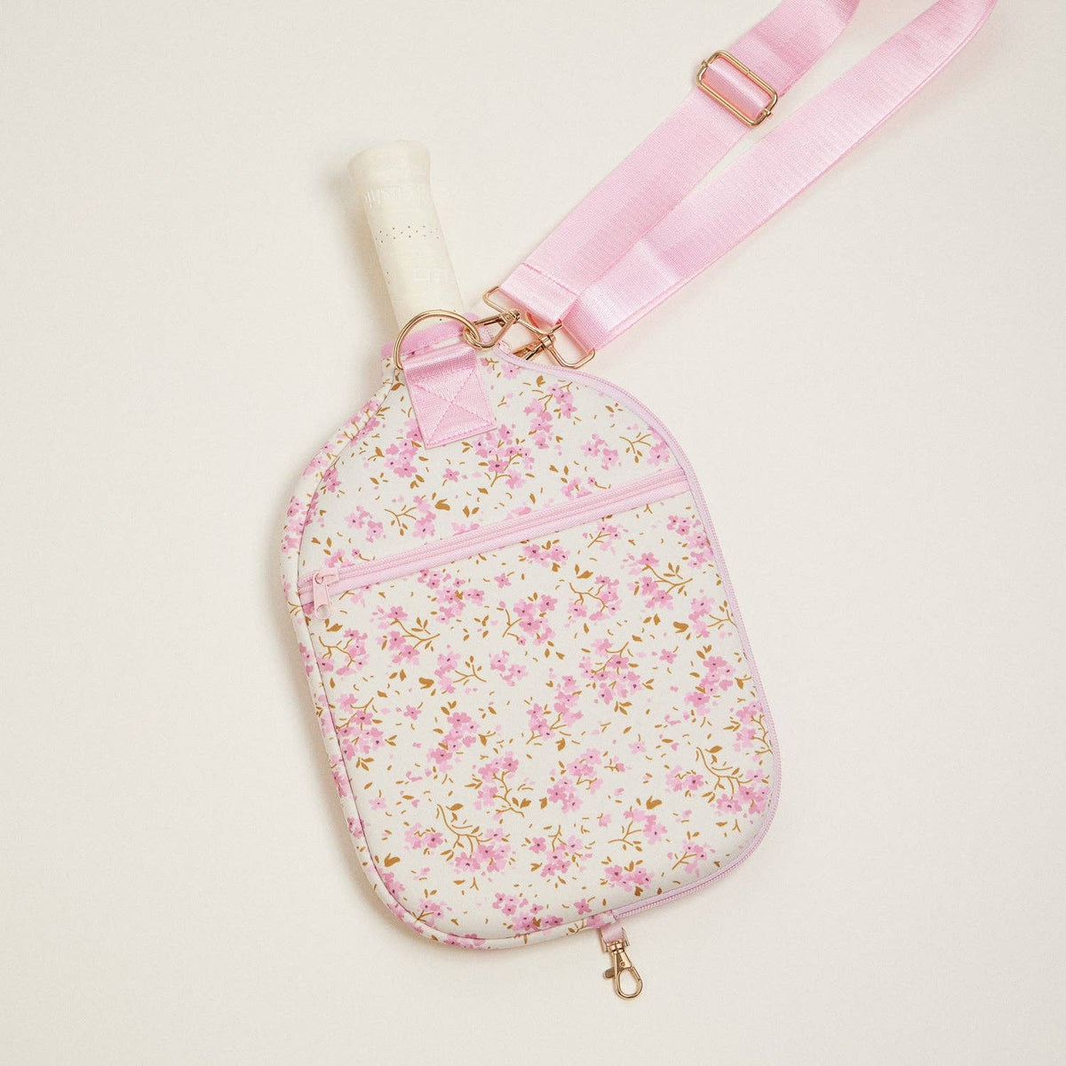 Floral neoprene pickleball paddle bag with pink strap, gold-tone clips, and zip pocket