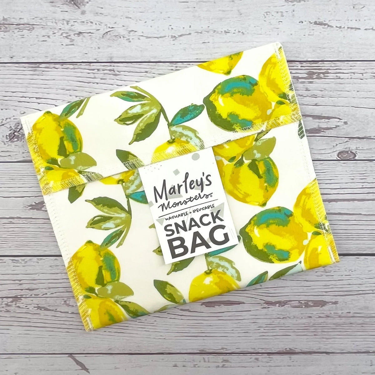 Reusable snack bag with yellow lemon print on white fabric, sealed top flap.