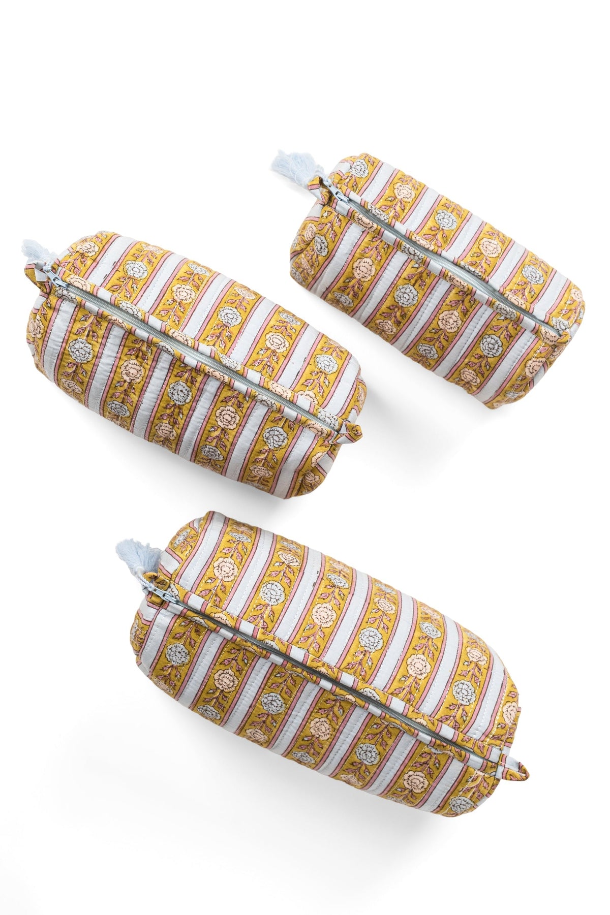 Three striped makeup pouches with tassels, zip tops in gold and blue