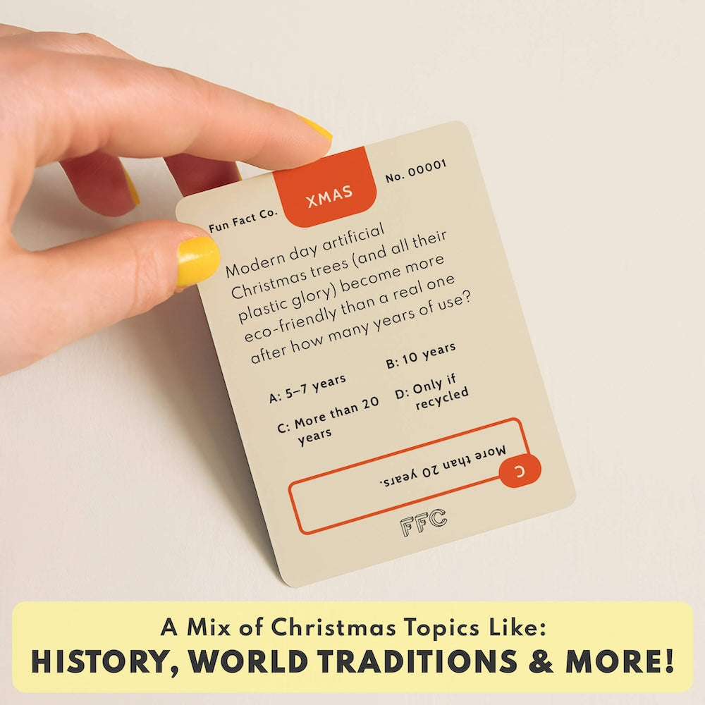 Close-up of hand holding red “XMAS” trivia card labeled No. 00001