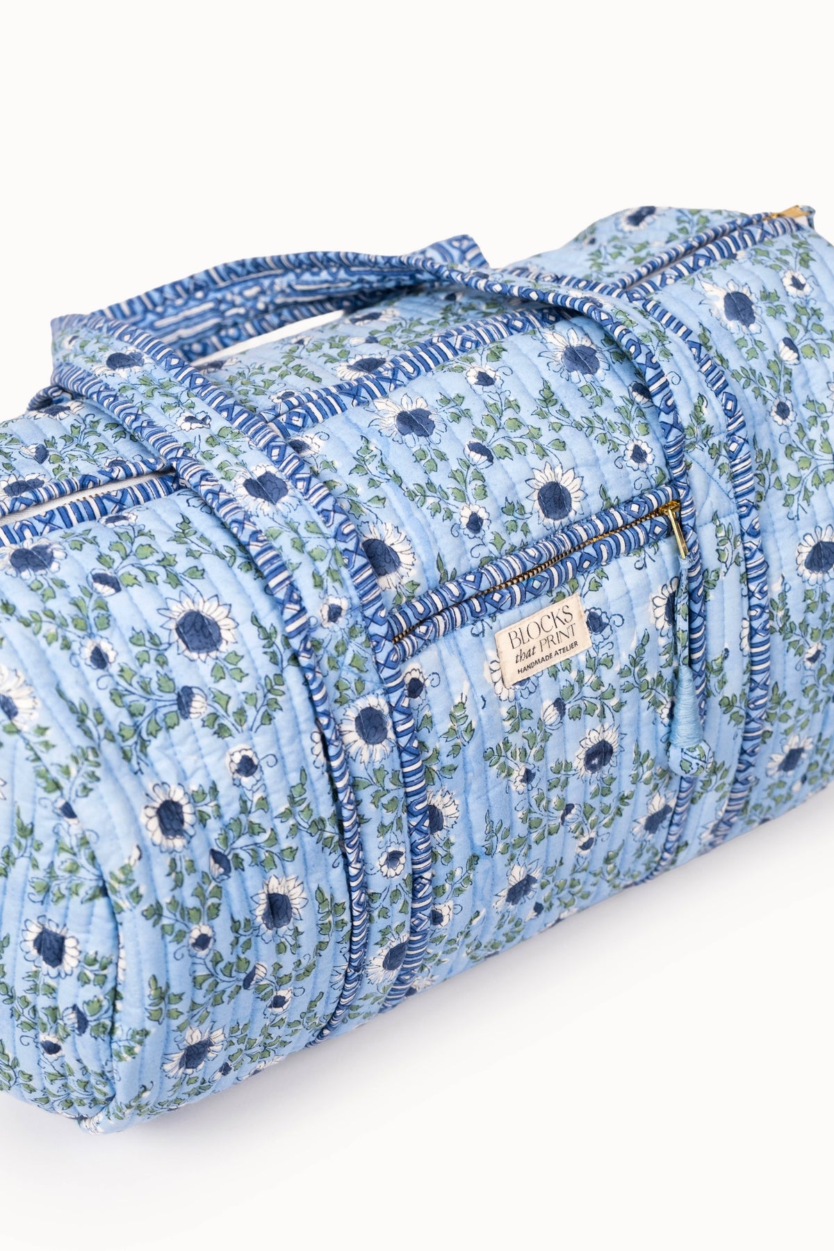 Quilted block print duffle bag in light blue with blue piping and side handles