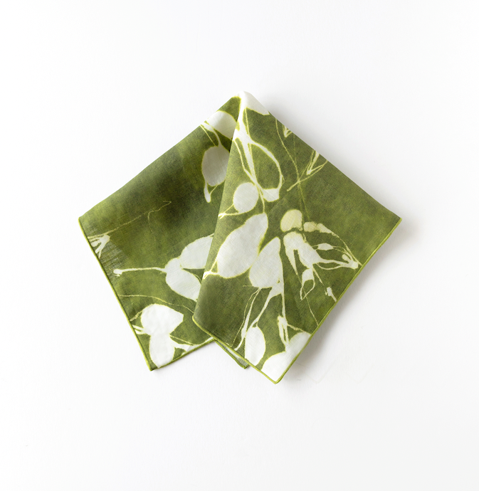 Folded olive napkin with white floral print, corner overlapping