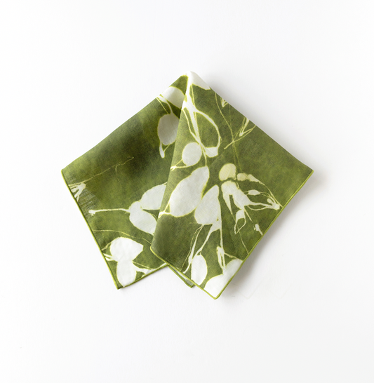 Folded olive napkin with white floral print, corner overlapping