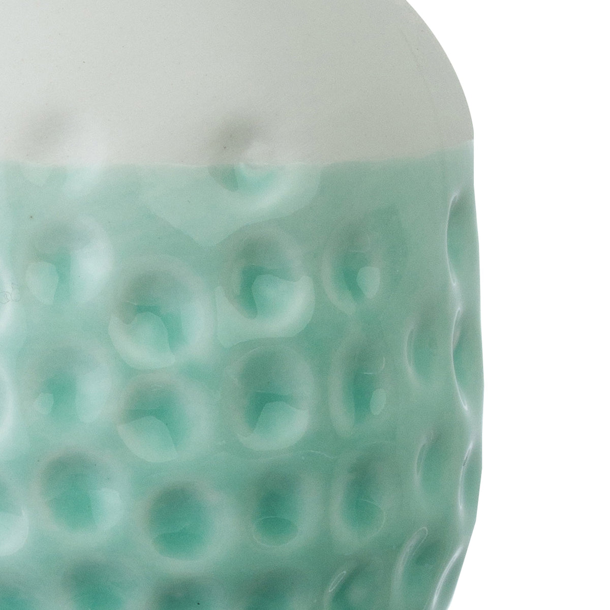 Close-up of pale teal ceramic vase with embossed dot pattern texture