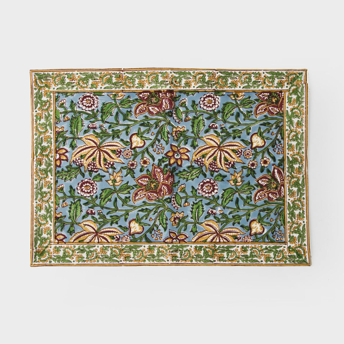 Cotton placemat with green and blue floral pattern and decorative border