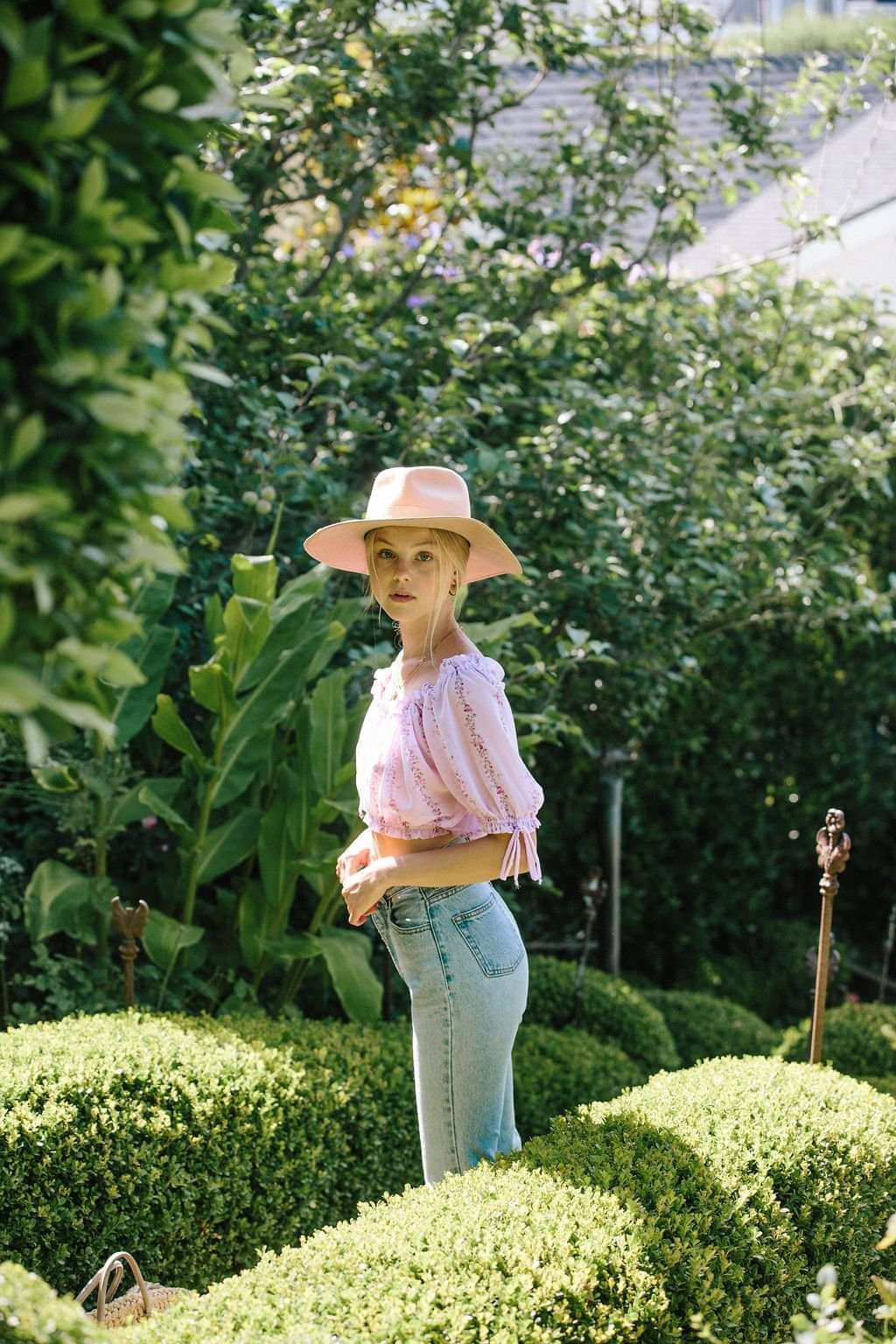 Light purple floral cropped blouse with puff sleeves, paired with light-wash jeans in garden