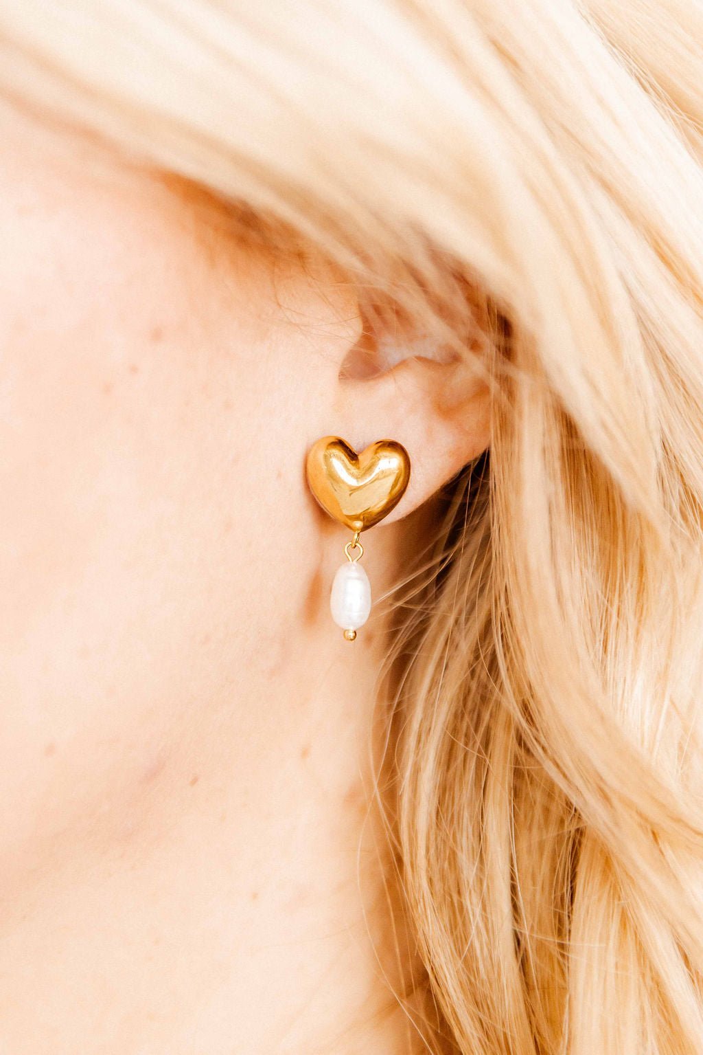 Gold-tone heart stud earrings with dangling pearl drops and small heart charm.