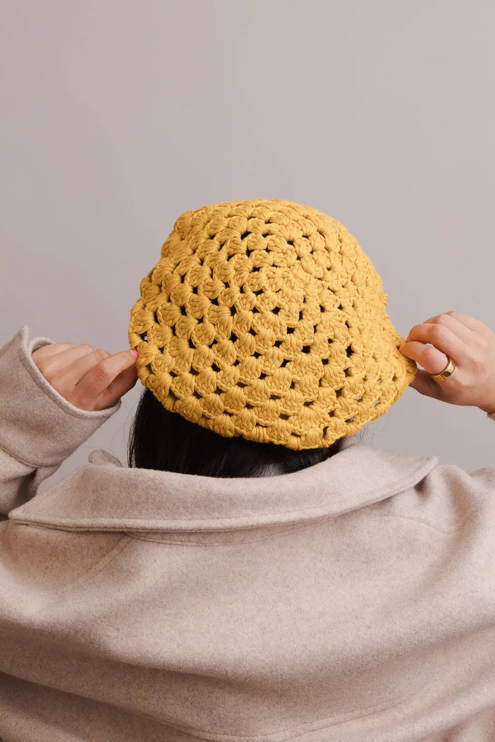 Mustard crochet knit beret with diamond stitch, held up for detail