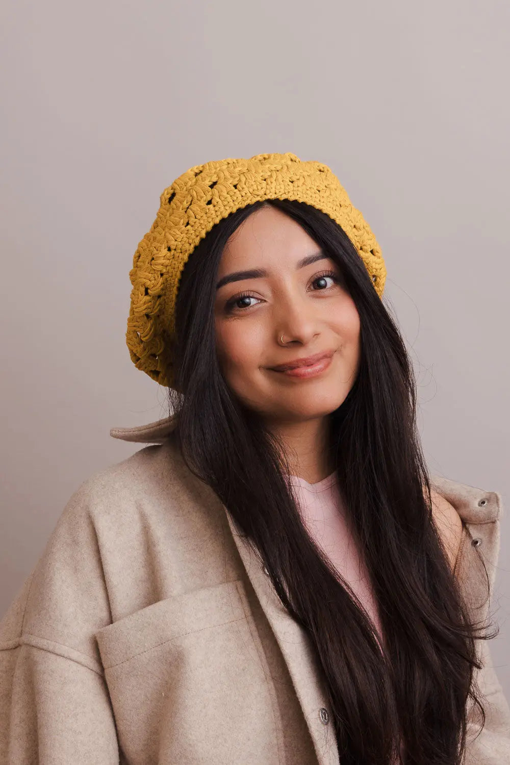 Mustard crochet knit beret with diamond stitch, worn front-facing on model