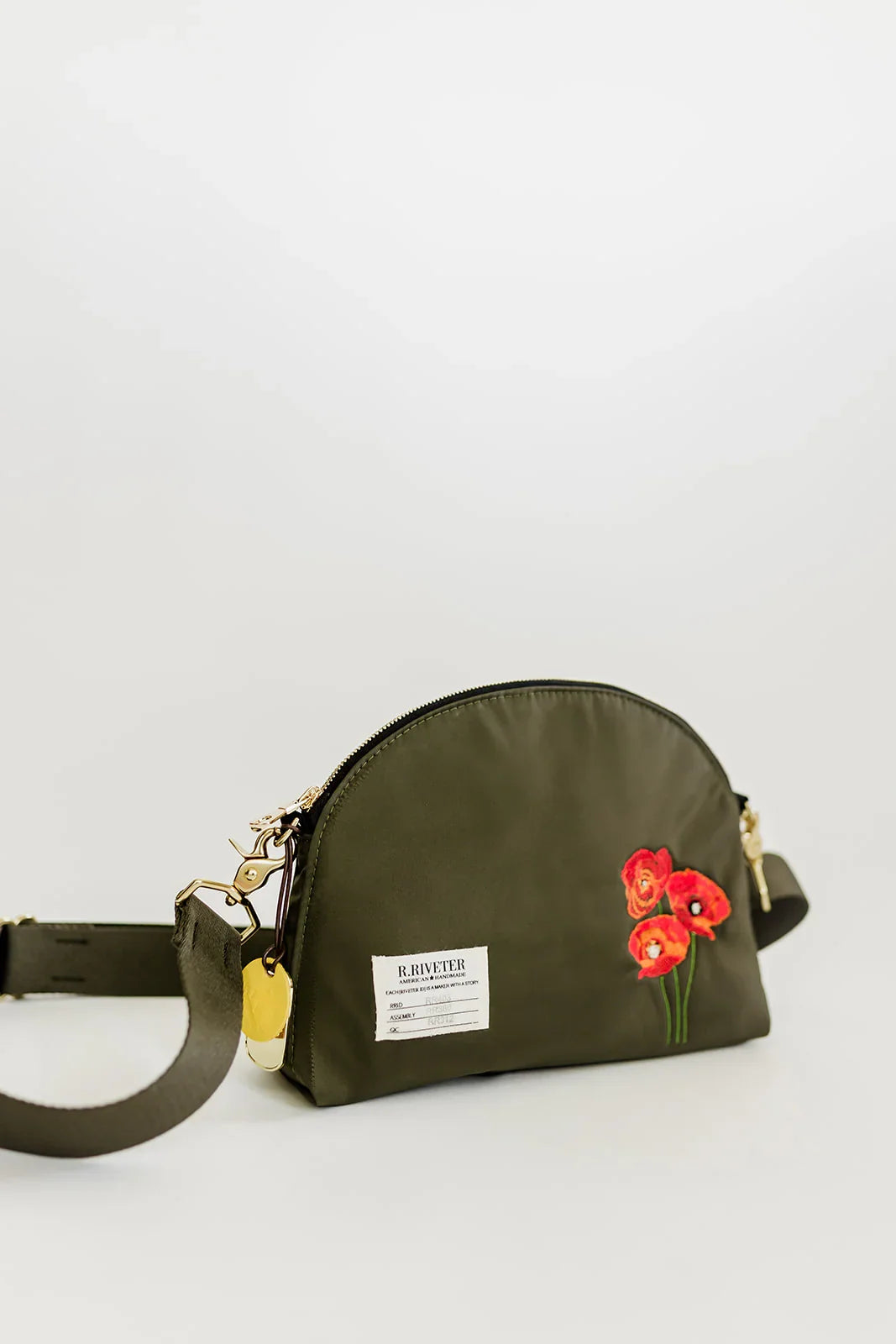 Olive nylon dome crossbody bag front view with red poppy embroidery and shoulder strap