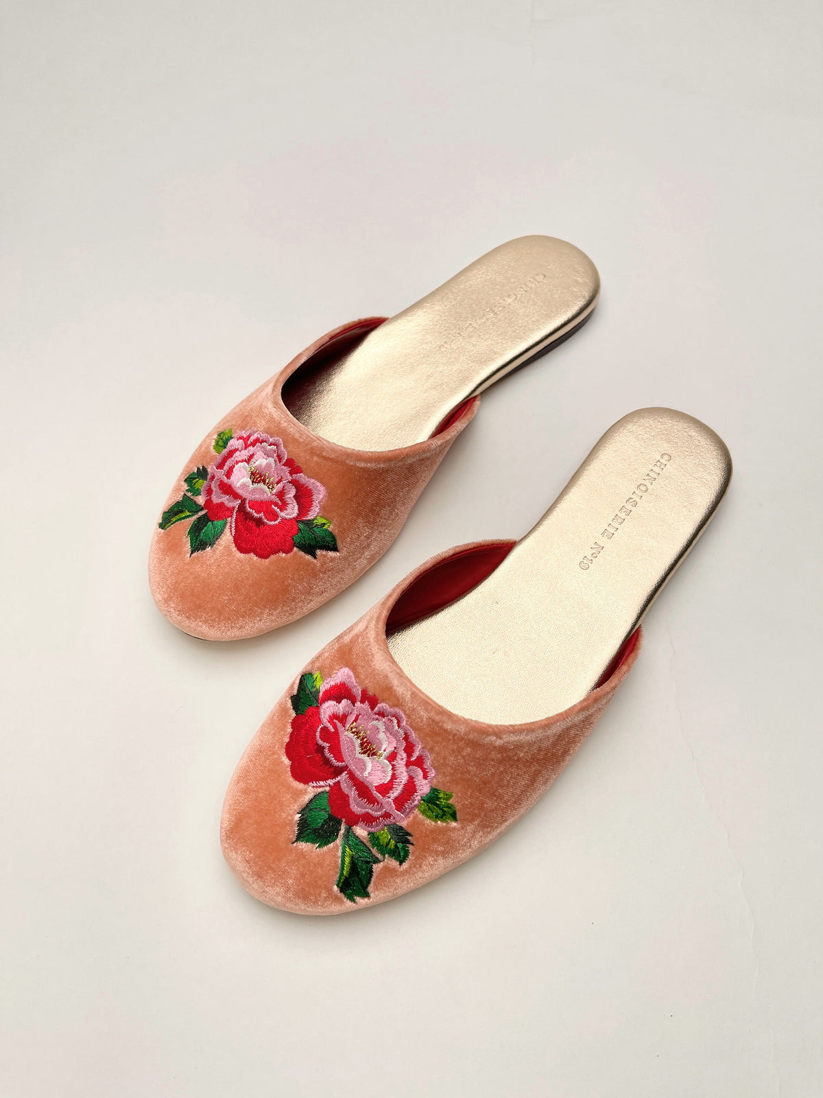 Peach velvet embroidered mules showing front opening and cream footbeds
