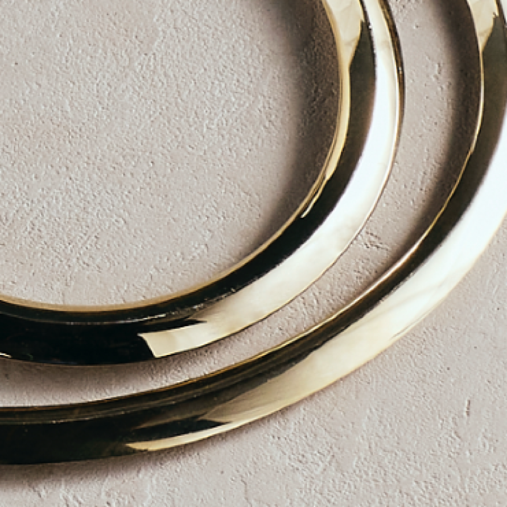 Gold metal oval ring trivet edge with polished reflective surface
