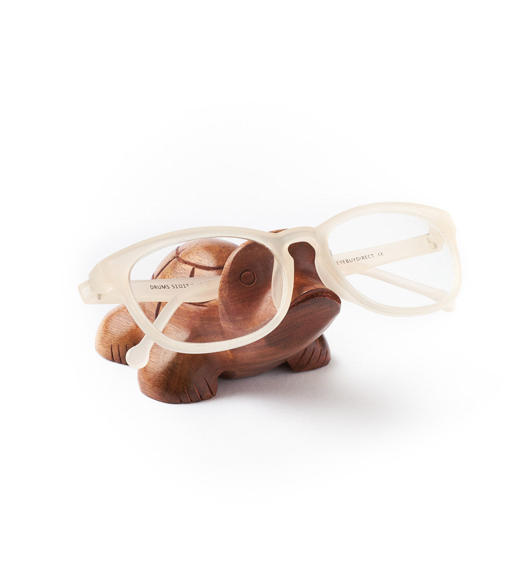 Turtle eyeglasses holder with clear glasses resting on the curved top.