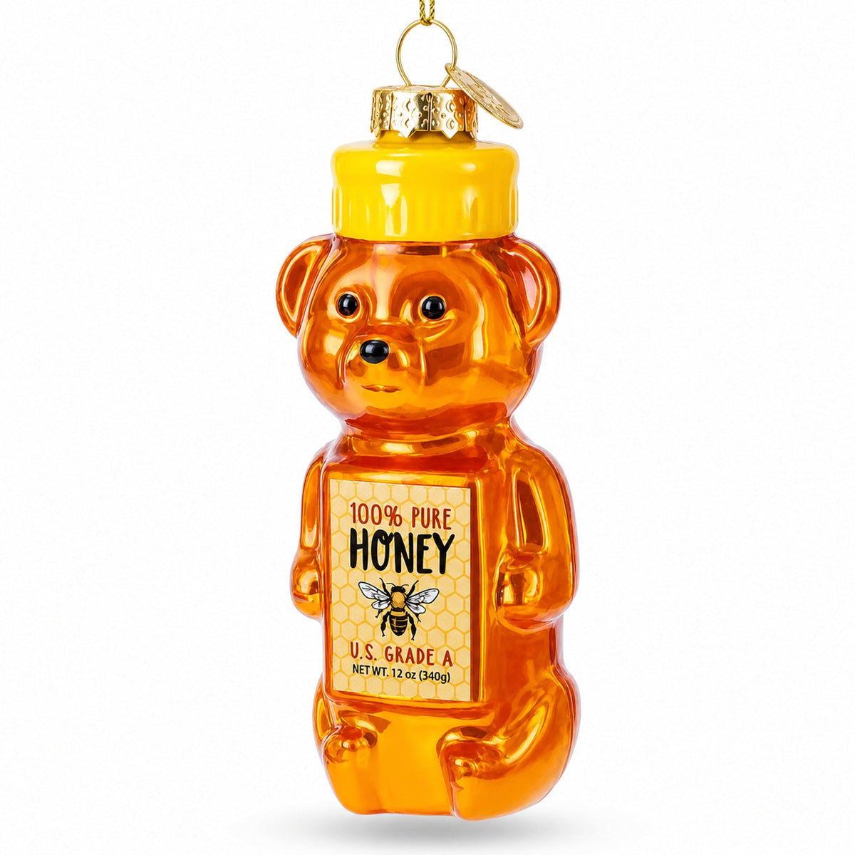 Honey-colored glass bear Christmas ornament with yellow cap and front label detail