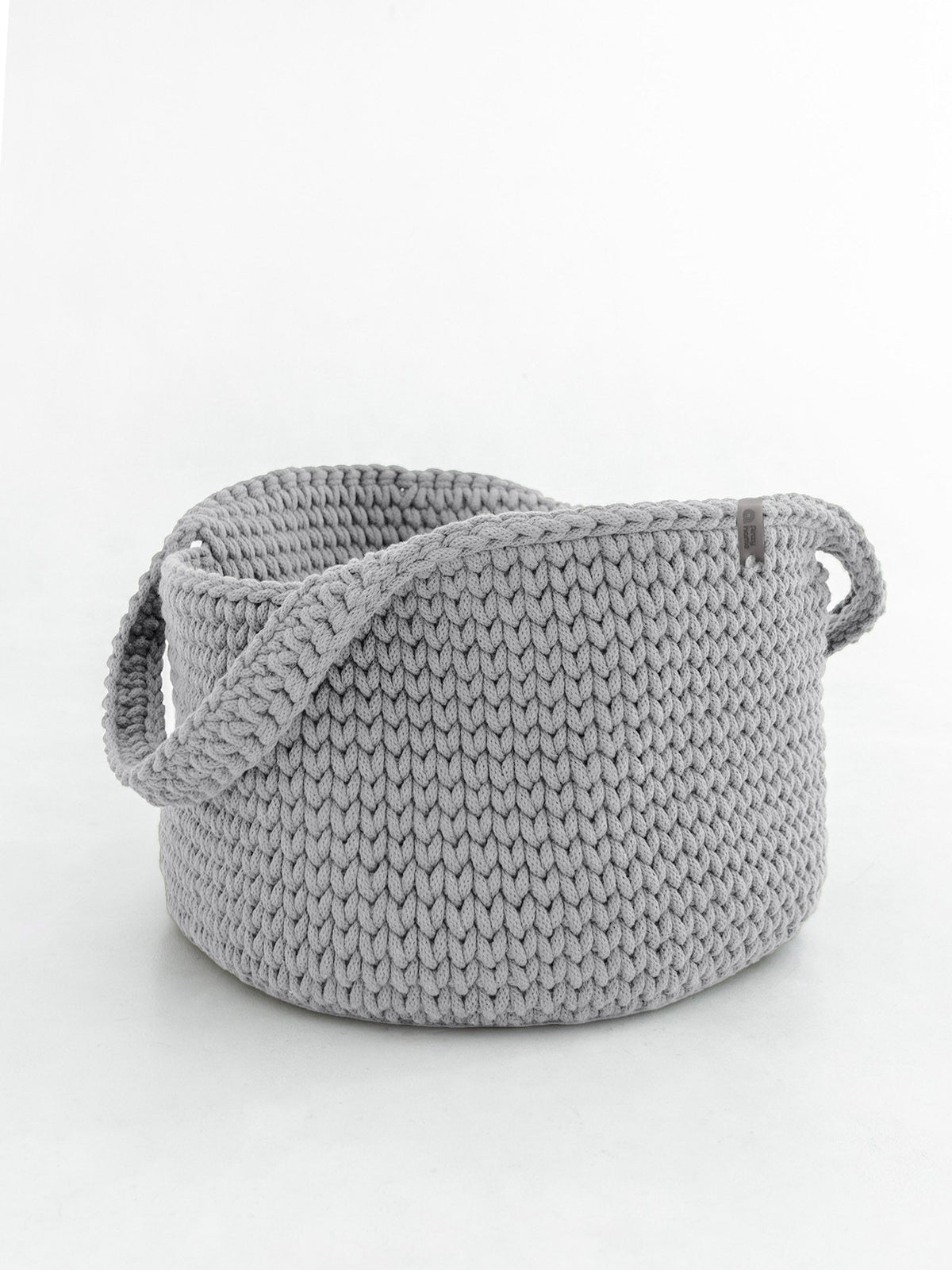 Round knitted storage basket with handles in light gray, textured knit body
